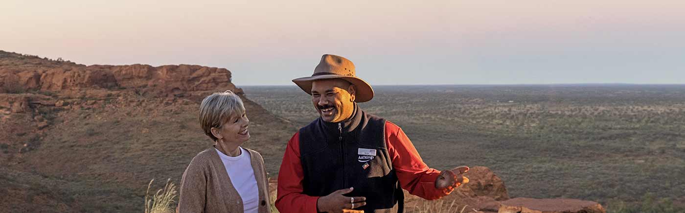 AAT-Kings image of two people having a discussion in a desert environment in Australia