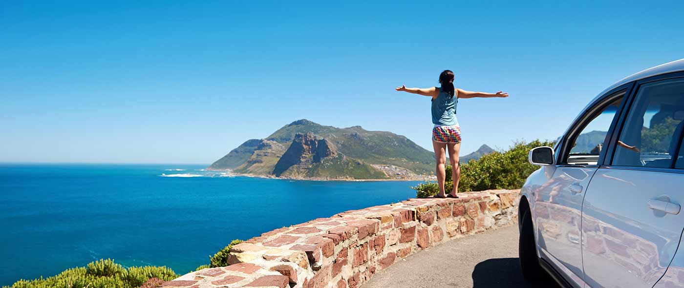 Image of a woman on a rock wall with her arms outstretched.